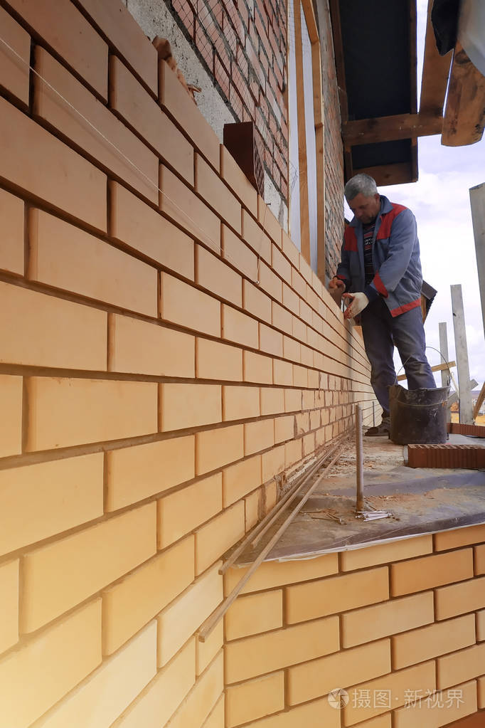 主人用前面的砖砌了一堵房子的墙