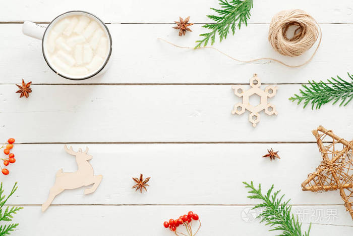 圣诞作文。热巧克力与棉花糖杯，冷杉树枝，圣诞装饰在乡村木白色背景。最小平面布置，顶视图，复印空间。寒假概念