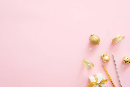圣诞金色装饰在淡粉色的背景上,带有复制空间.