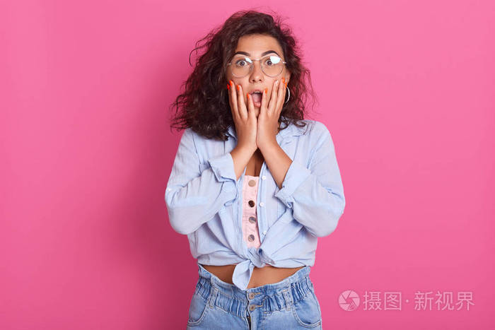 惊骇女性的特写镜头张开嘴双手放在脸颊上被惊呆了美丽