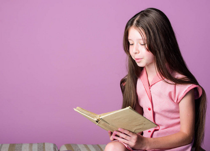 可爱的小孩在紫罗兰色背景上看书.小女孩学读书.家庭教育理念.求知欲.