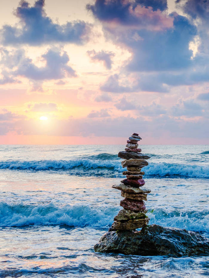 海滩上的一堆鹅卵石阳光明媚背景是美丽的天空