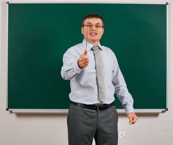 一个情绪化的说话男人的画像穿着西装的学校老师在黑板前摆姿势学习和