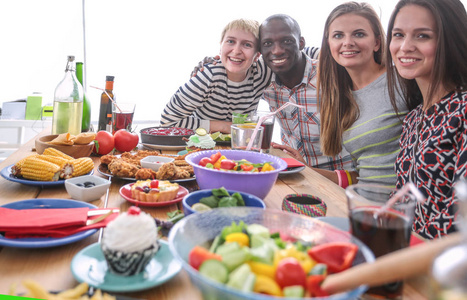 坐在木桌旁吃饭的人群的俯视图.餐桌上的食物.人们吃快餐.照片