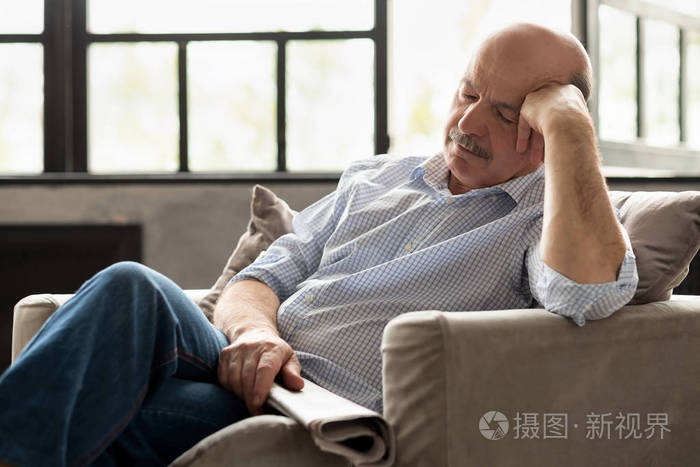 疲惫的西班牙老人睡在沙发上午睡
