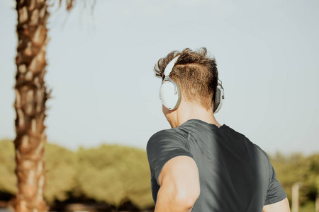 高加索人去高加索男人带着大耳机跑步听音乐照片