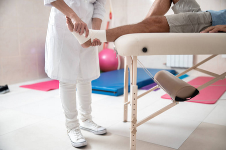 结扎手术女医生正在给男人做腿部结扎手术照片