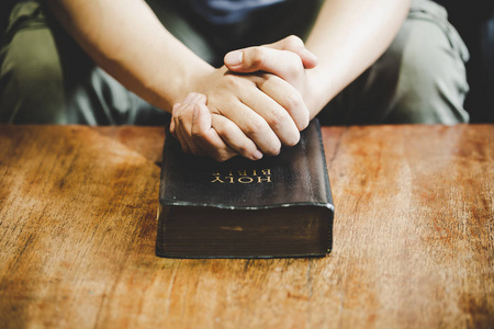 精神和宗教,双手合十在神圣的圣经上祈祷照片
