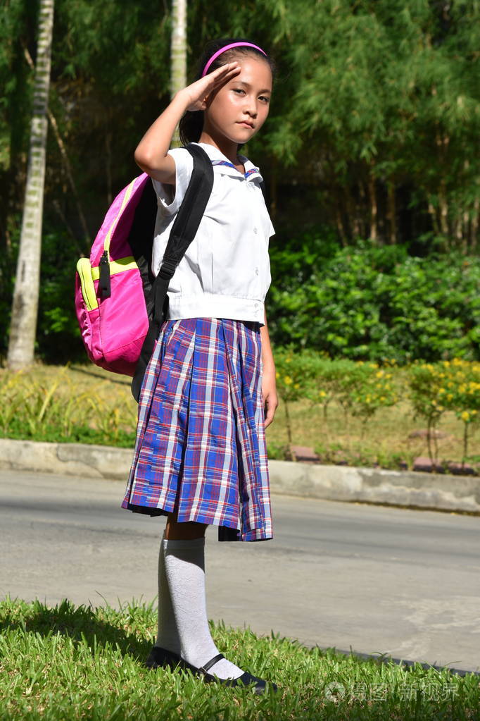 可爱的菲律宾学生少年穿着制服和笔记本致敬