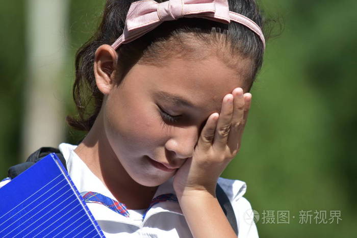 悲伤的学生少女拿着笔记本