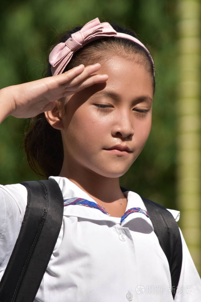 一个可爱的亚洲女生在敬礼