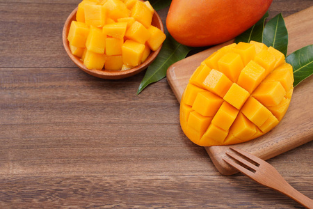 切碎的水果新鲜的芒果,漂亮的切碎的水果和绿色的叶子在深色的木制