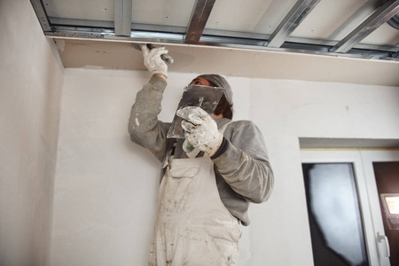 建筑工人在屋内粉刷石膏墙.照片
