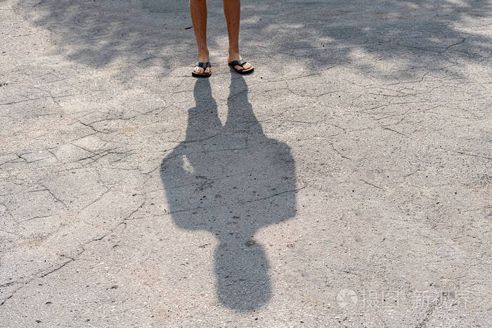 下午站在城市柏油路上的人的影子