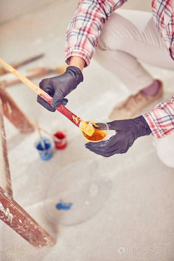 女工在屋内粉刷墙壁