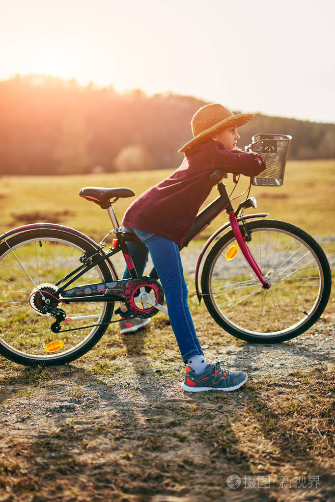 可爱的十岁小女孩骑自行车在乡下