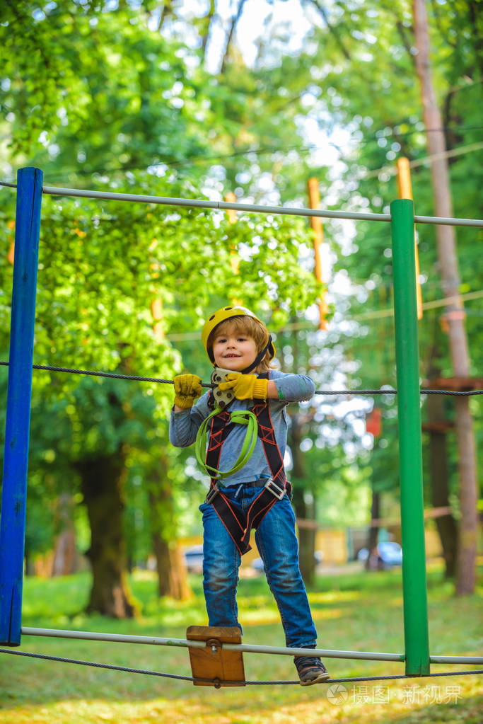 一个漂亮的孩子在树间的绳索公园里的画像.孩子.