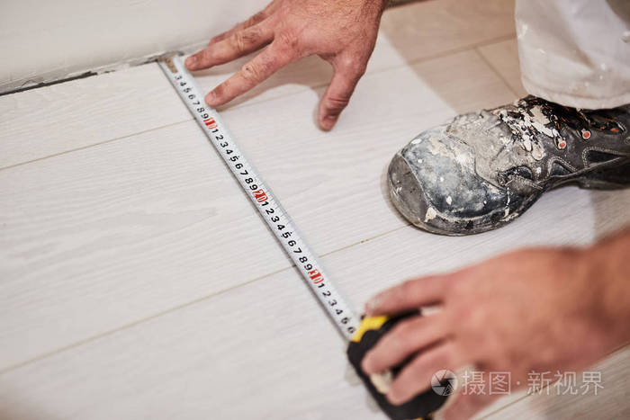 用卷尺测量房屋装修的工人