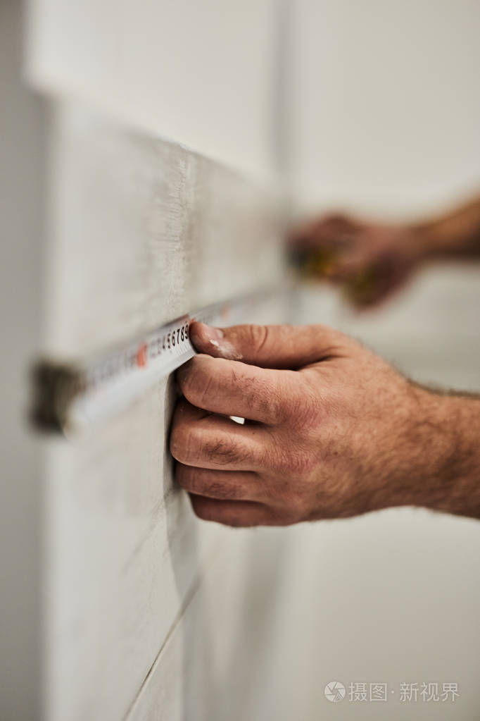 用卷尺测量房屋装修的工人