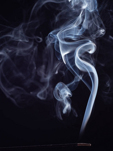 抽象图案的白色烟雾从燃烧的香,孤立在黑色背景,特写镜头.