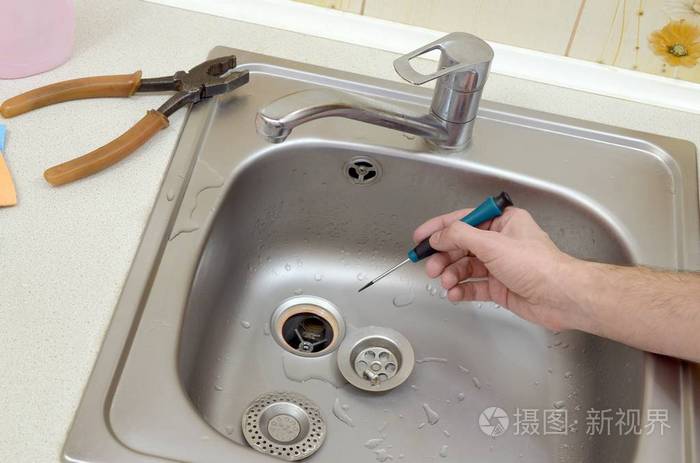 帅气管道工手修理厨房水槽排水管的特写镜头
