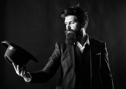 戴帽子的人.复古时尚.深色背景下,一位仪容整洁大胡子的绅士照片