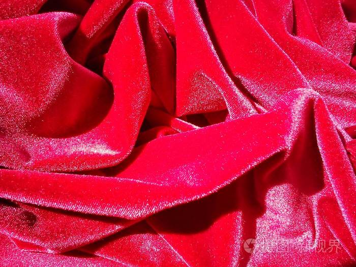 一条红丝绒在阳光下皱巴巴地闪闪发光