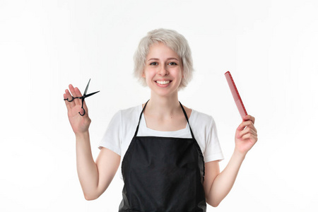 毛刷和剪刀漂亮的理发师穿着白色t恤和黑色围裙,手持黑色剪刀和红色发