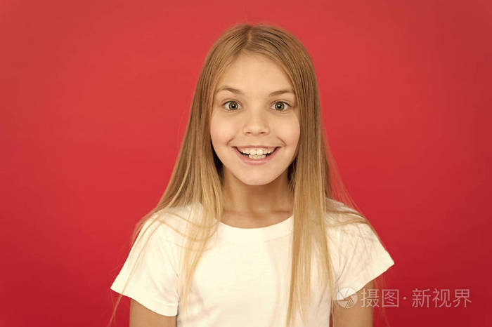 红色背景下的女孩可爱的笑脸.情绪激动的孩子开心的笑脸.真挚的情感.