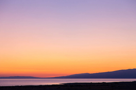 朝阳的光芒,橙色.吉尔吉斯斯坦,伊塞克湖.明亮的天空,暖色的背景.照片