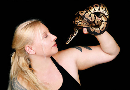 带着皇家蟒蛇的女孩肖像.美女双手捧着蛇,在镜头前摆姿势.