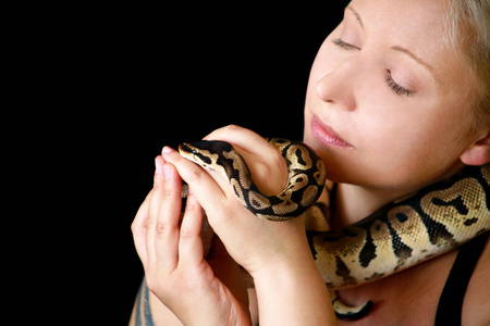 一名女子双手抱着蟒蛇的脖子,在镜头前摆姿势.