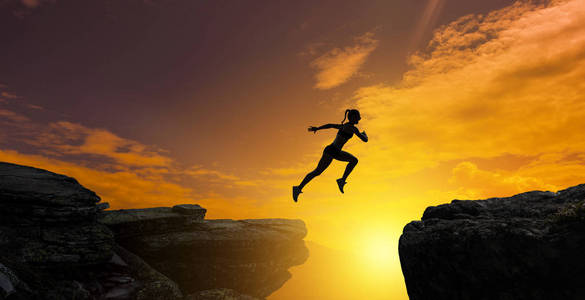 女性力量石头跳崖,挑战概念.照片