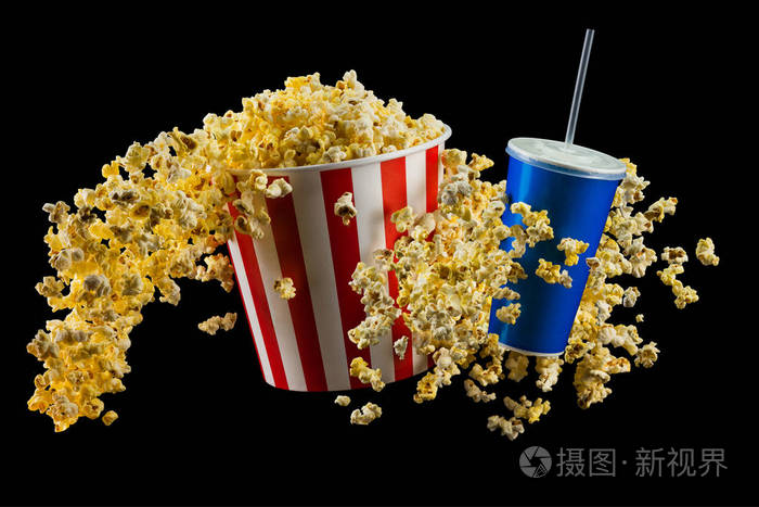 一套纸条桶装有爆米花和一杯黑色隔离的软饮料