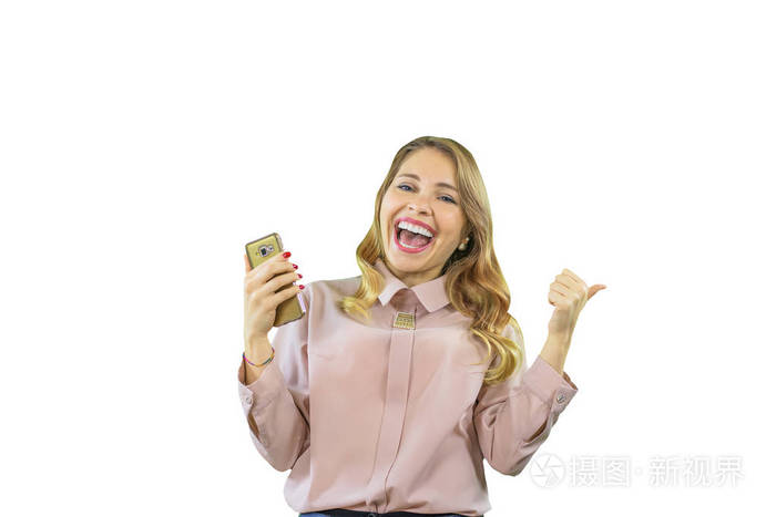 一个穿着衬衫的迷人而快乐的金发女孩正侧身站着看着她手中的手机看着