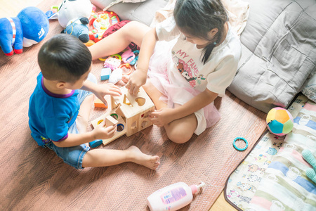 亚洲可爱的小孩坐着玩玩具盒图片