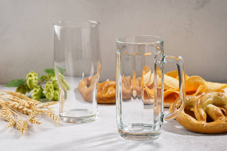 干净的空啤酒杯和一个盛满各种小吃的杯子.照片