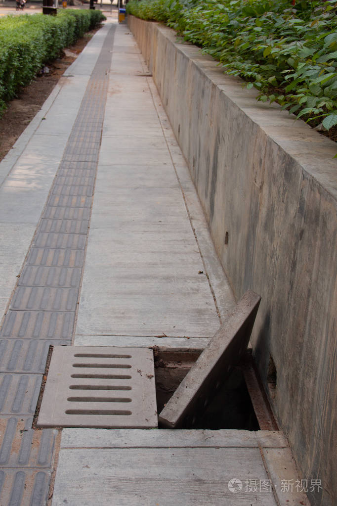 人行道上带混凝土明格栅的污水排水沟下水道