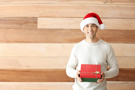 木质背景上有圣诞礼物的帅哥图片