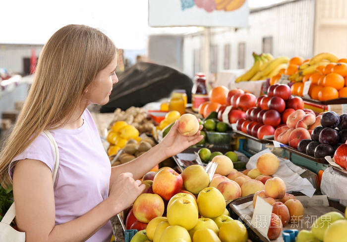 在市场上挑选水果的女人