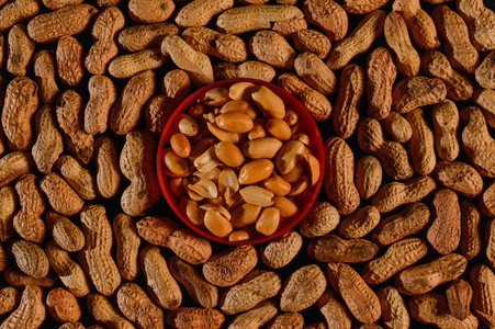 白色塑料板加工花生呈贝壳状纹理,背景为花生配塑料板照片