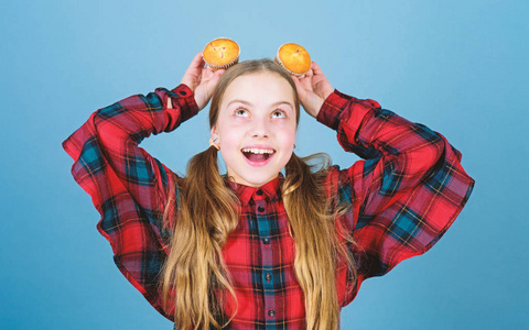 小孩子开心地笑着,头上顶着纸杯蛋糕甜点.快乐的小女孩喜欢吃甜点.