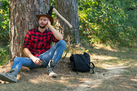 年轻的伐木工人正在木头上砍圣诞树年轻的樵夫冬季肖像留胡子的人把
