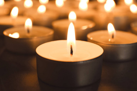 蜡烛灯在黑暗中黑暗中在桌上点蜡烛,特写.葬礼符号照片