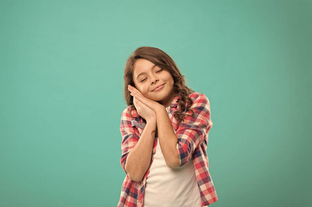 小女孩用手捂住脸颊作为睡觉的手势.晚安,做个好梦.