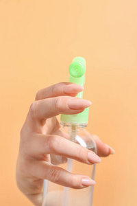 女性手拿瓶空气清新剂在彩色背景上,特写照片