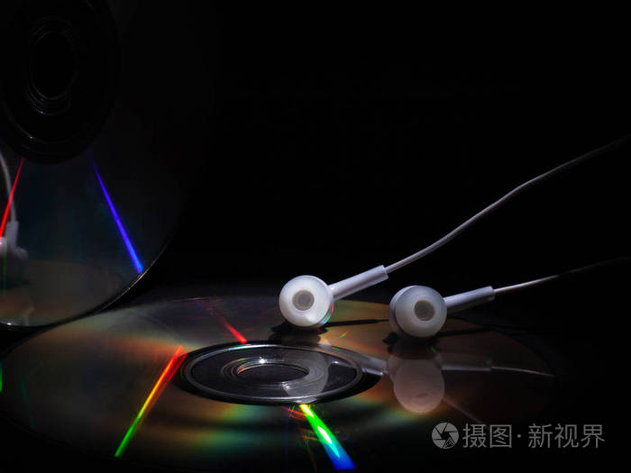 cd光盘和白色耳机背景为深色概念听音乐