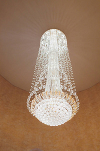 内饰为棕色,米色.房间有大窗户,米色墙壁和天花板中央的水晶吊灯.照片