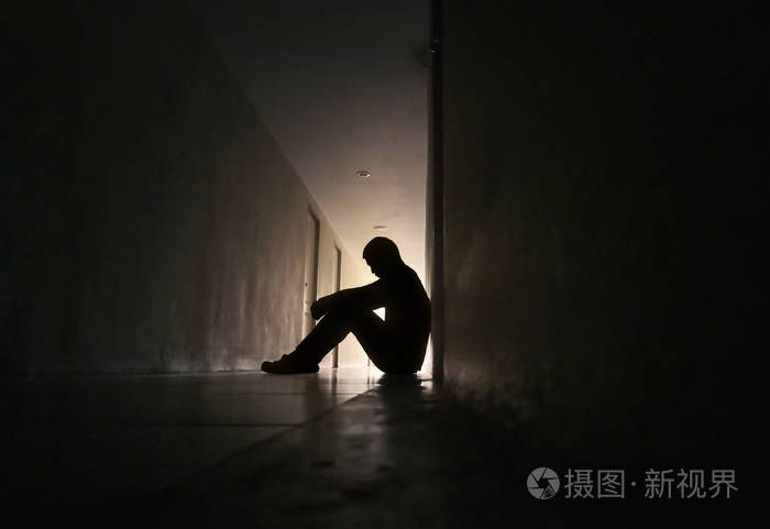 坐在住宅楼走道上的沮丧男人的侧影悲伤的男人哭泣戏剧孤独和不快乐的