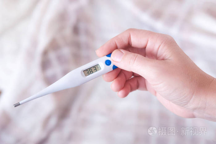 一个女人看着温度计的特写镜头女性手拿着数字温度计女孩量体温以温度